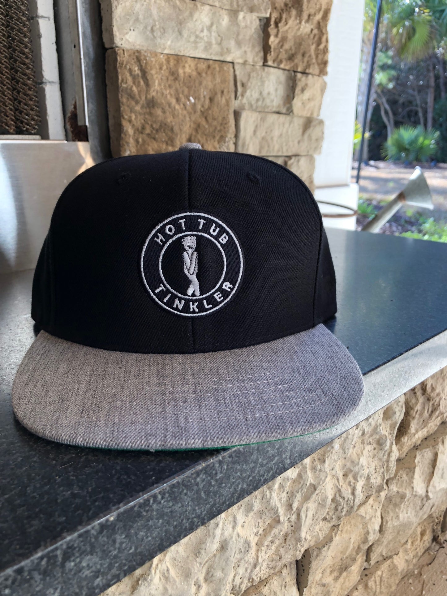 hot tub tinkler flat bill hat on counter top
